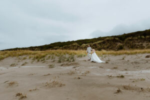 Couple takes a beach walk at their oregon coast vow renewal