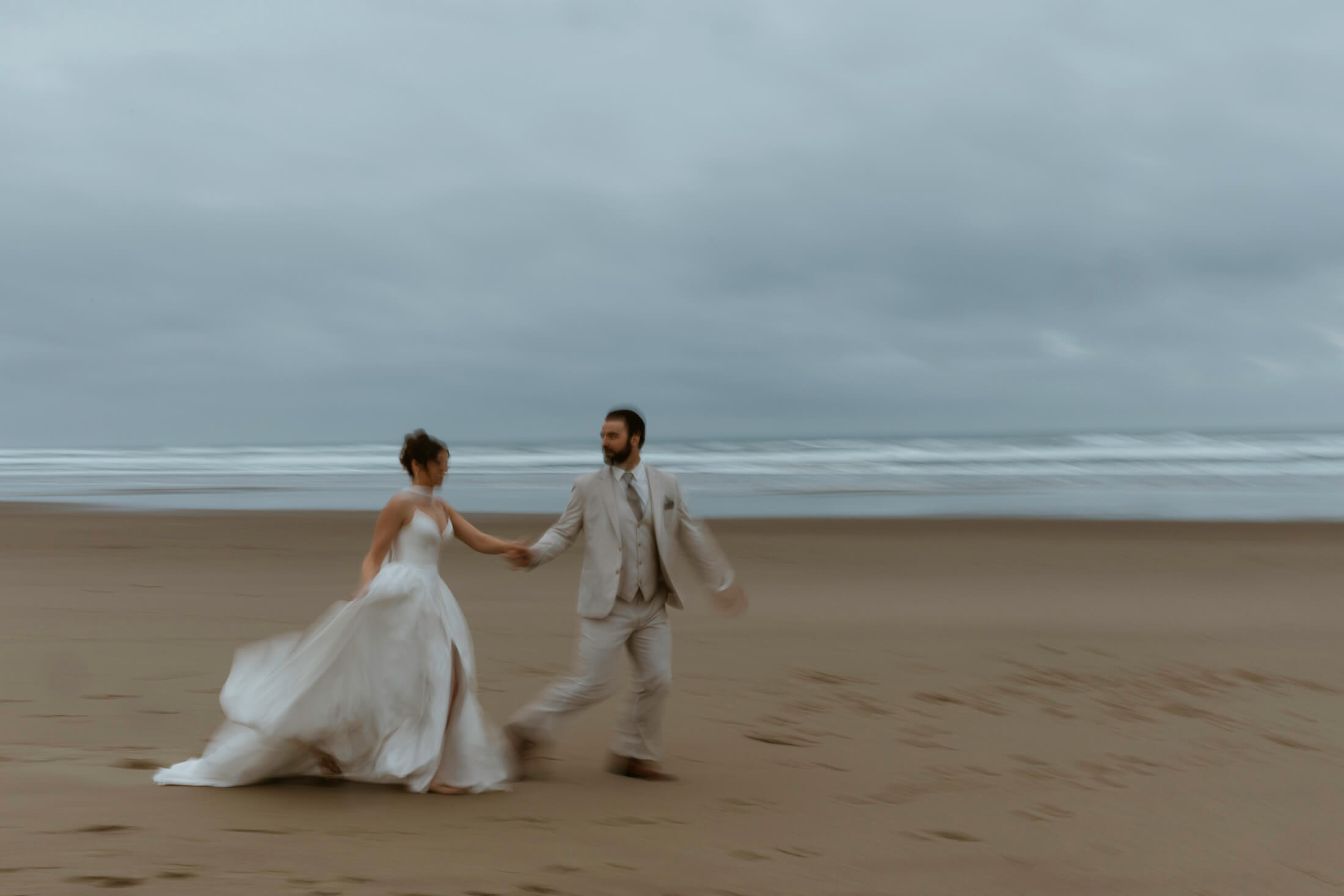 Couple runs on the beach at their oregon coast vow renewal