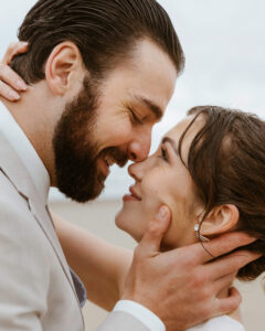 Couple exchanges a kiss in the rain at their oregon coast vow renewal