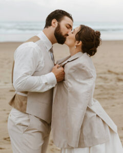 Groom puts a jacket on his bride at their oregon coast vow renewal