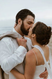 Groom puts a jacket on his bride at their oregon coast vow renewal
