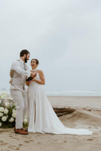 Couple pops a bottle of champagne at their oregon coast vow renewal