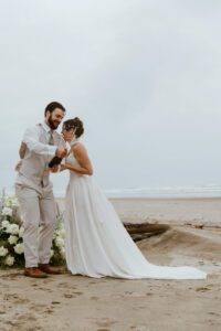 Couple pops a bottle of champagne at their oregon coast vow renewal