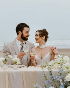 Couple pops a bottle of champagne at their oregon coast vow renewal