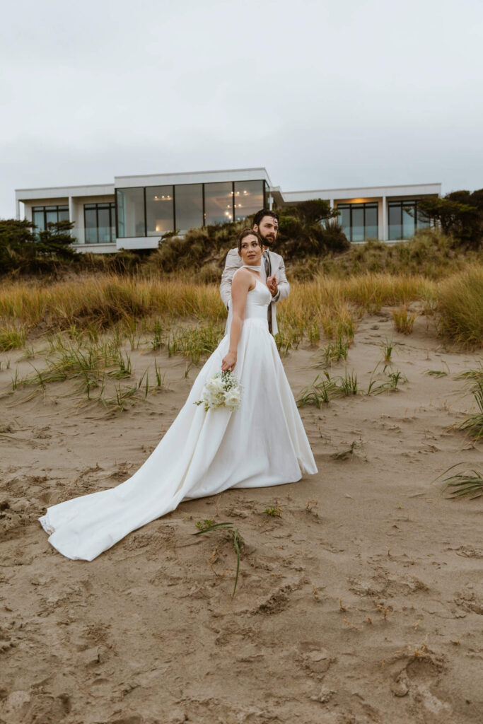 Couple walks on the beach near their rental home on the oregon coast after renewing their wedding vows