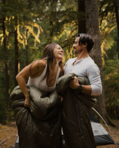 couple poses in sleeping bags at their camping photo session