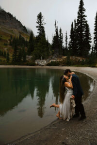 couple kisses next to an alpine lake on their mount rainier elopement hike