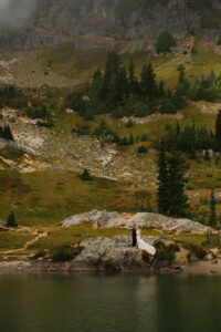 couple poses next to a lake at a mount rainier elopement
