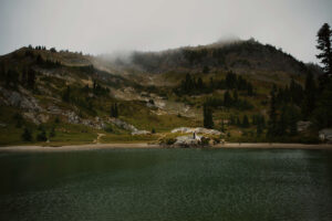 Couple poses next to an alpine lake on a mount rainier hike during their elopement
